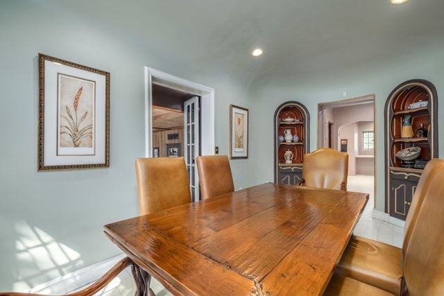 dining space with recessed lighting and arched walkways