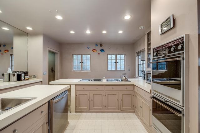 kitchen featuring sink, stainless steel dishwasher, and double oven