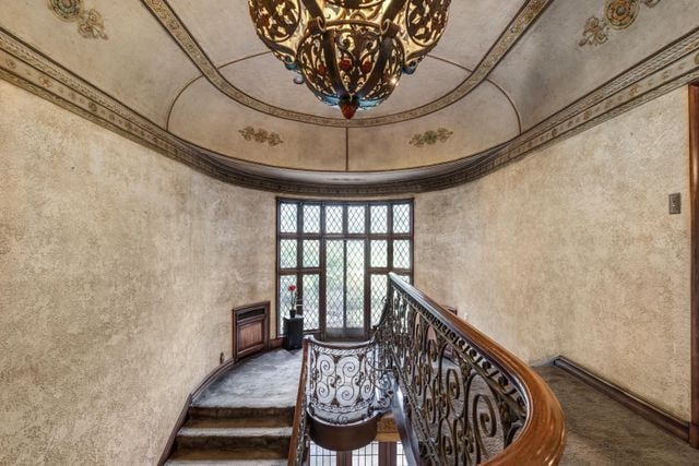 stairs featuring carpet flooring and a chandelier