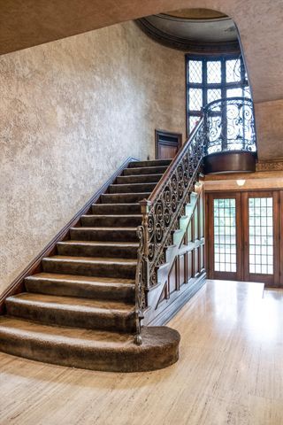 stairway with french doors, hardwood / wood-style floors, and a high ceiling