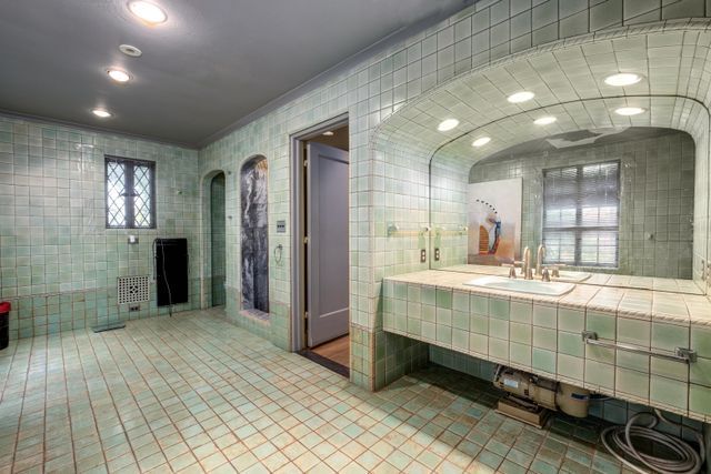 bathroom with tile walls, vanity, and tile patterned floors