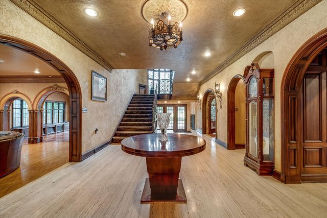 entryway featuring crown molding, a chandelier, and light wood-type flooring