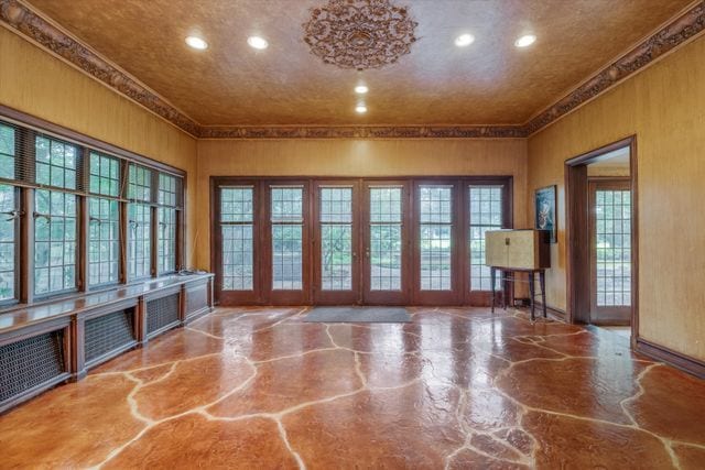 unfurnished living room featuring ornamental molding and concrete flooring