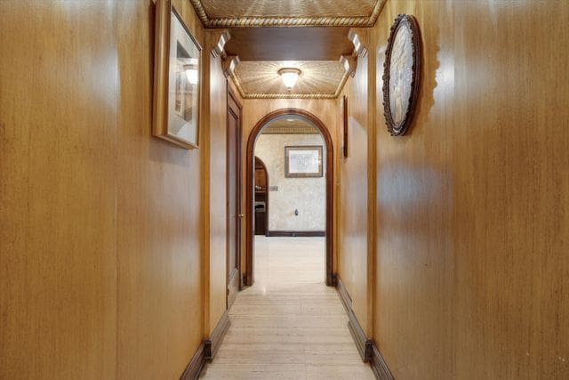 hallway with baseboards and arched walkways