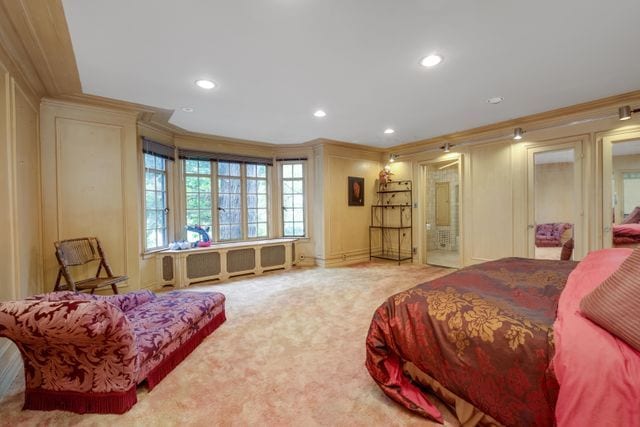 carpeted bedroom featuring a decorative wall, recessed lighting, and crown molding