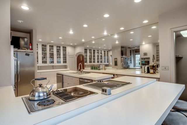 kitchen featuring white cabinets, stainless steel appliances, a kitchen breakfast bar, and a large island with sink