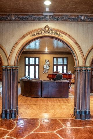 living room featuring parquet floors, crown molding, and decorative columns