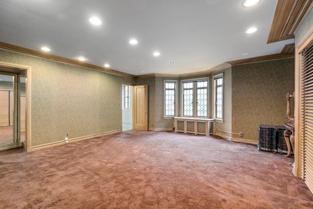 unfurnished living room featuring ornamental molding and carpet