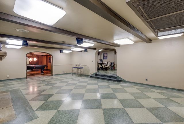 finished basement featuring pool table, tile patterned floors, baseboards, and arched walkways