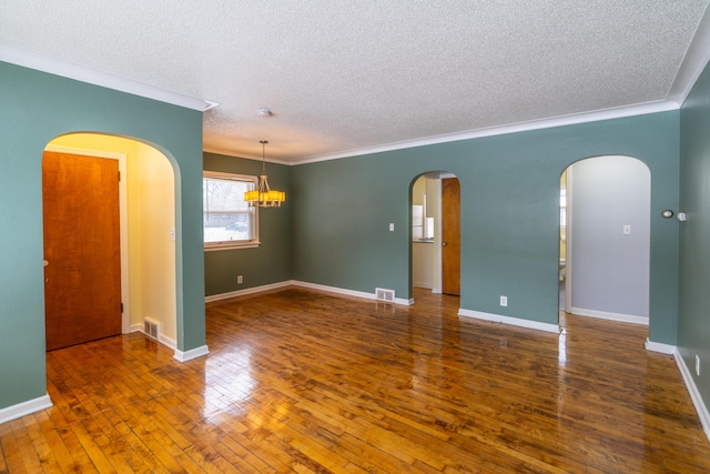 spare room with crown molding, dark hardwood / wood-style floors, and a textured ceiling