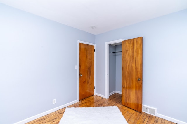 unfurnished bedroom with light hardwood / wood-style floors and a closet