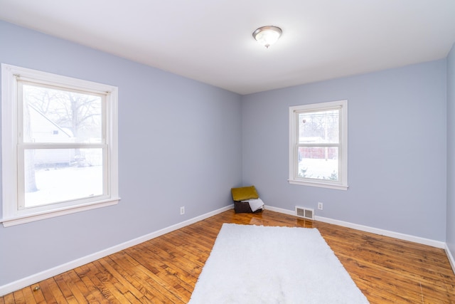 unfurnished room with hardwood / wood-style flooring