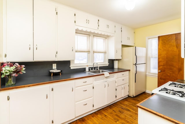 kitchen featuring white refrigerator, dark hardwood / wood-style floors, sink, and white cabinets