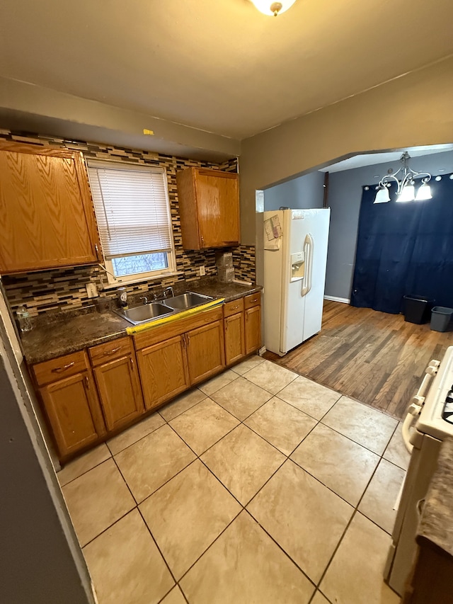 kitchen with light tile patterned flooring, white appliances, sink, and tasteful backsplash