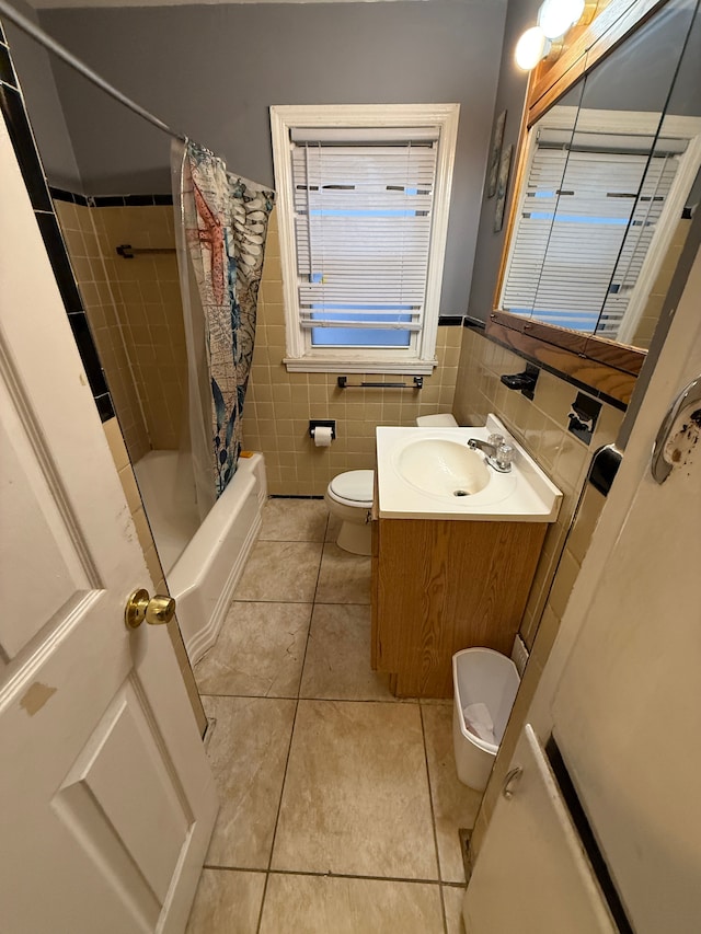 full bathroom with tile walls, vanity, tile patterned floors, toilet, and shower / bath combo with shower curtain