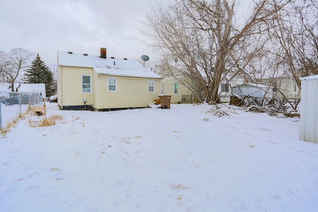 view of snow covered rear of property