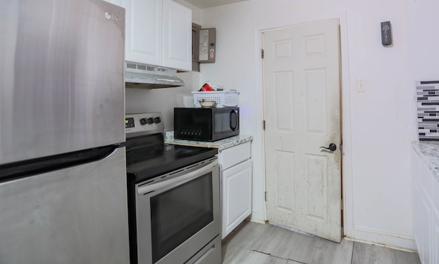 kitchen featuring stainless steel appliances, white cabinets, light stone counters, and light hardwood / wood-style floors