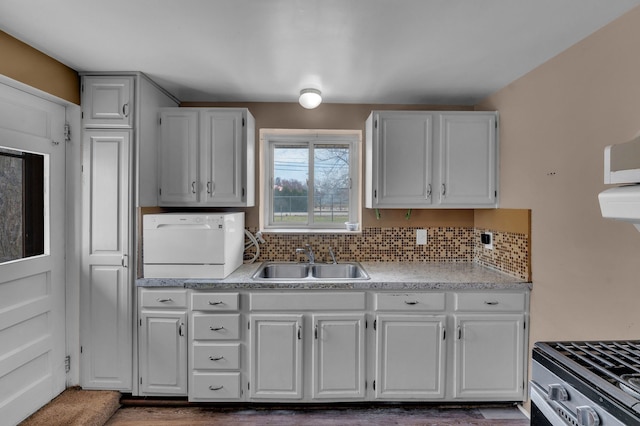 22810 E 13 Mile Rd, Saint Clair Shores, MI 48082 - kitchen with a sink, washer / clothes dryer, light countertops, gas stove, and white cabinets