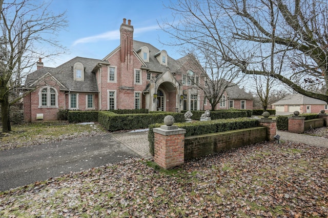 view of front of home with brick siding and a chimney