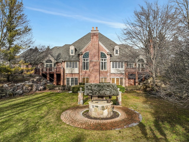 rear view of property featuring a deck, a lawn, and a chimney