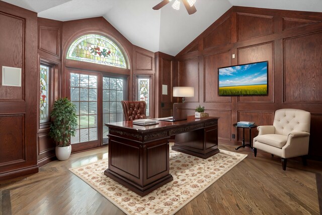 office with a decorative wall, wood finished floors, and high vaulted ceiling