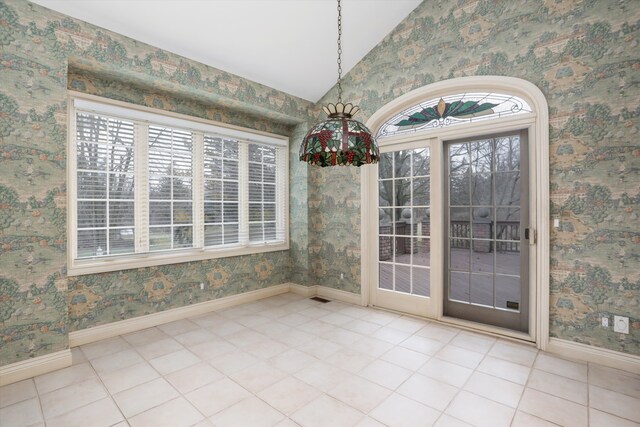 interior space with tile patterned floors, lofted ceiling, and wallpapered walls