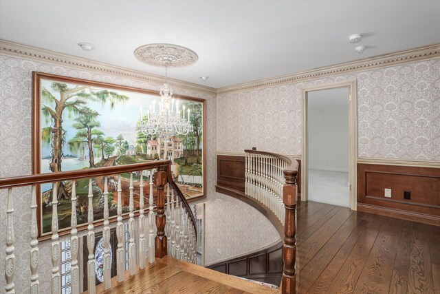 interior space featuring wallpapered walls, hardwood / wood-style flooring, a wainscoted wall, and an inviting chandelier