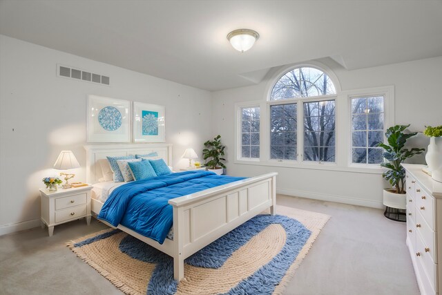 bedroom featuring visible vents, baseboards, and light colored carpet