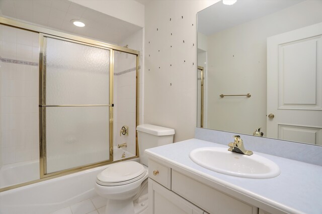 bathroom with vanity, tile patterned floors, toilet, and shower / bath combination with glass door