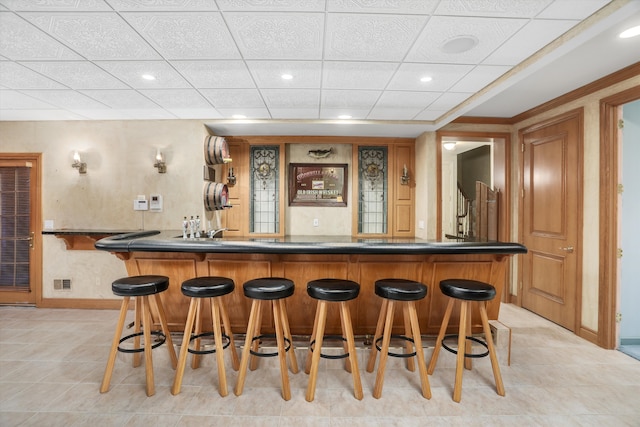 bar with baseboards, visible vents, recessed lighting, a drop ceiling, and indoor wet bar