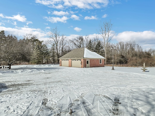 snowy yard featuring a detached garage