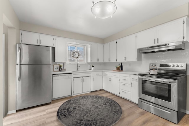 kitchen featuring stainless steel appliances, sink, light hardwood / wood-style flooring, and white cabinets