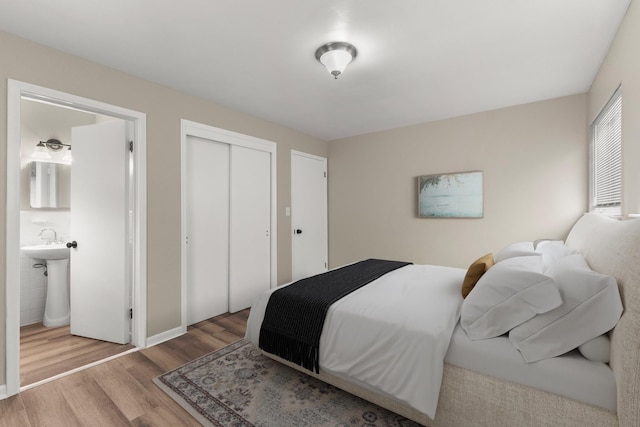 bedroom featuring sink, light hardwood / wood-style floors, and a closet