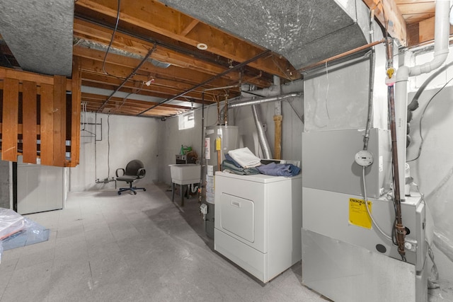 basement with heating unit, washer / clothes dryer, gas water heater, and sink