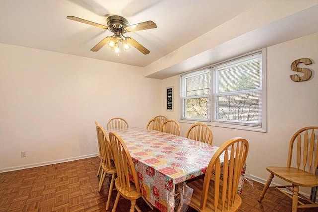 dining area featuring dark parquet floors and ceiling fan