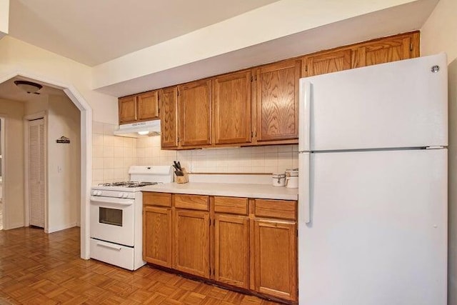 kitchen with tasteful backsplash, white appliances, and light parquet floors