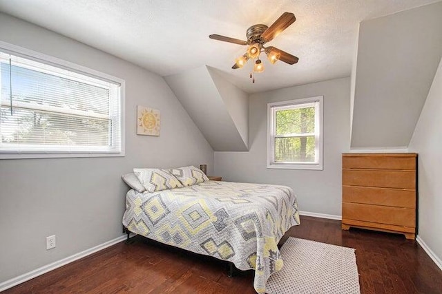 bedroom featuring dark hardwood / wood-style flooring, vaulted ceiling, and ceiling fan