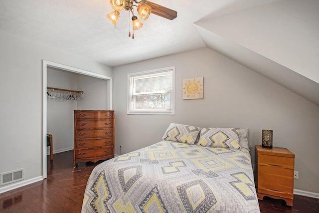 bedroom with lofted ceiling, a textured ceiling, dark hardwood / wood-style flooring, and a closet