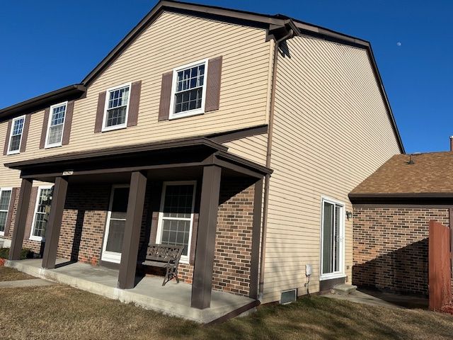 rear view of property featuring a yard and a patio area