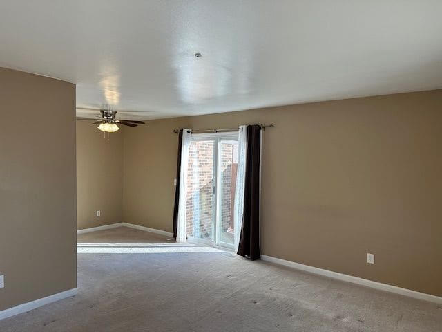 carpeted spare room with ceiling fan