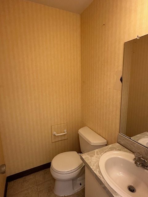 bathroom with tile patterned flooring, vanity, and toilet