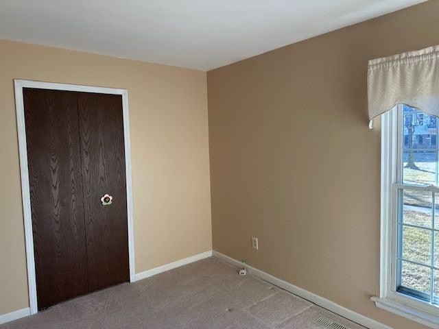 unfurnished bedroom with light colored carpet and a closet