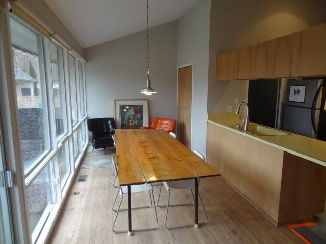 dining room featuring high vaulted ceiling, light hardwood / wood-style floors, and sink