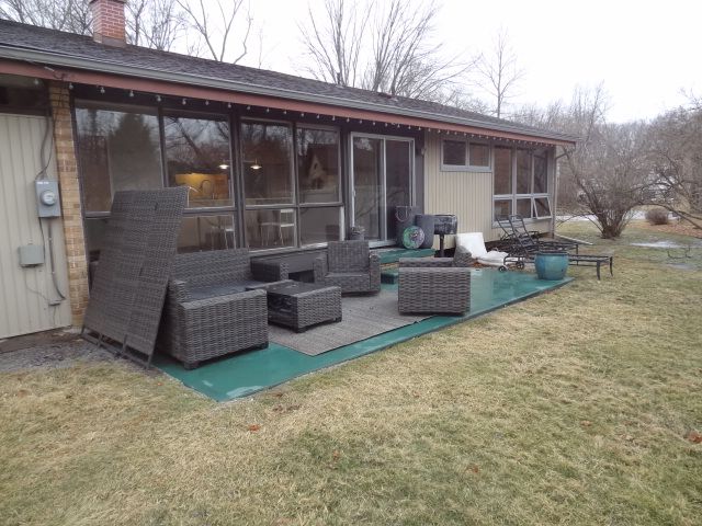 rear view of property with an outdoor living space, a sunroom, and a lawn