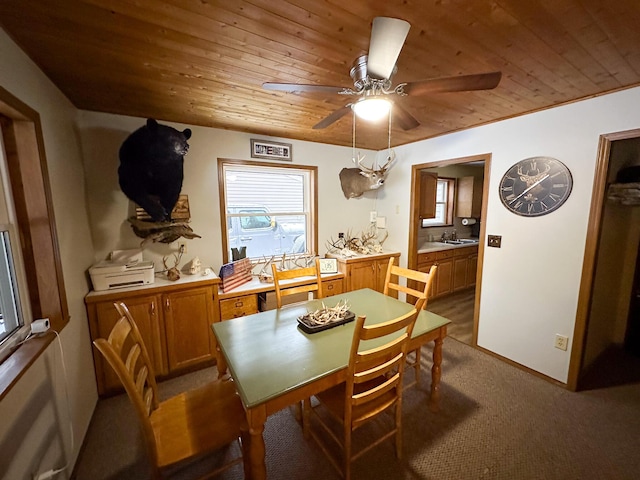 dining area with ceiling fan, sink, light colored carpet, and wood ceiling