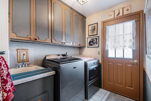 washroom featuring light tile patterned floors, cabinets, and washer and dryer