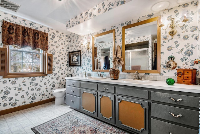 bathroom featuring vanity, toilet, and a shower with shower door