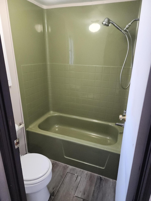 bathroom with hardwood / wood-style flooring, shower / bathing tub combination, and toilet