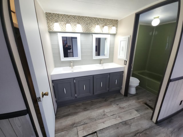 bathroom with wood-type flooring, vanity, and toilet