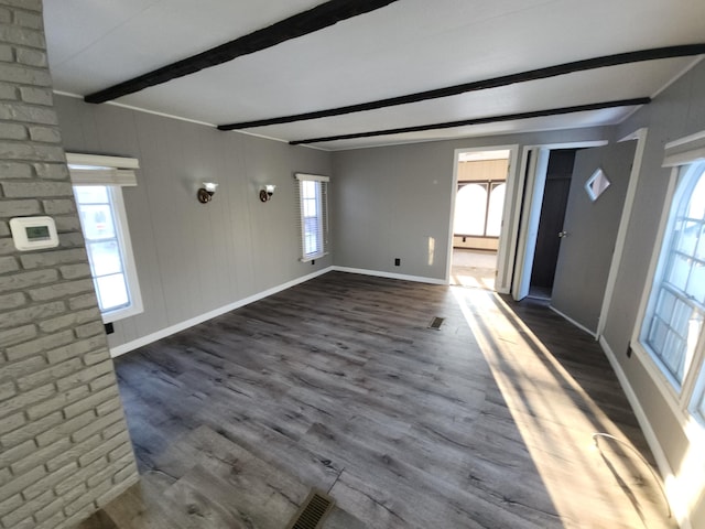 interior space featuring dark wood-type flooring and beam ceiling